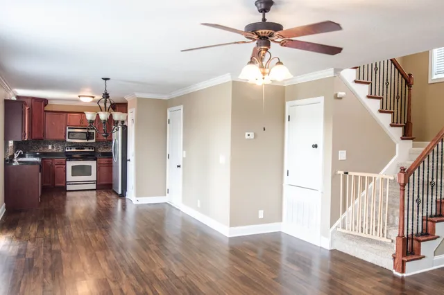a view of a kitchen with wooden floor appliances and a ceiling fan