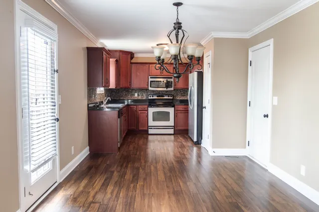 a kitchen with stainless steel appliances granite countertop a stove and a refrigerator