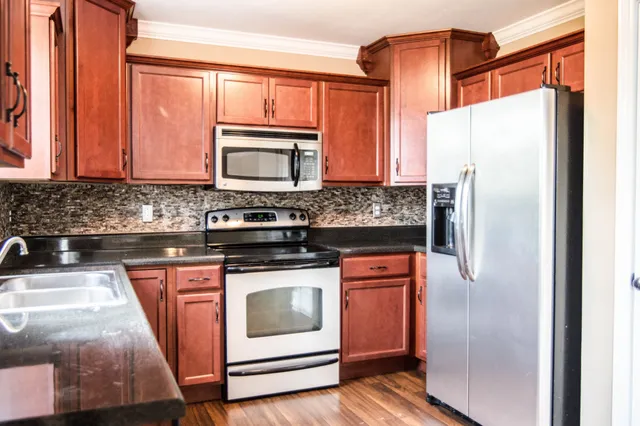 a kitchen with stainless steel appliances granite countertop a refrigerator stove and sink