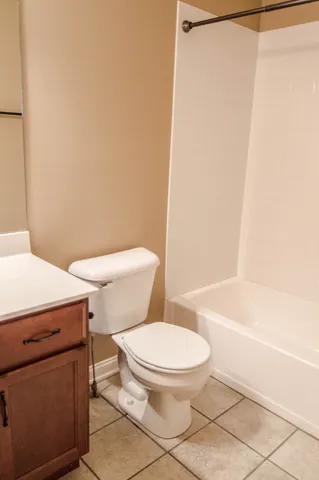 a white toilet sitting next to a bath tub and a shower