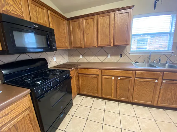 a kitchen with stainless steel appliances a microwave a stove a sink and a microwave