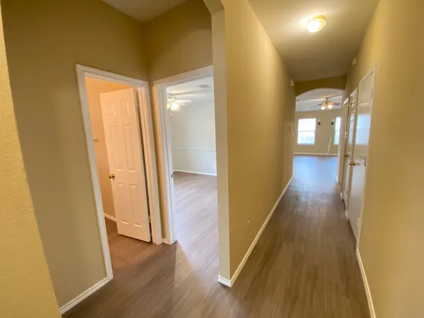 a view of a hallway with wooden floor