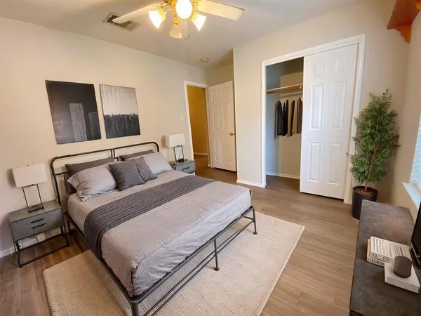 an empty room with wooden floor and closet area