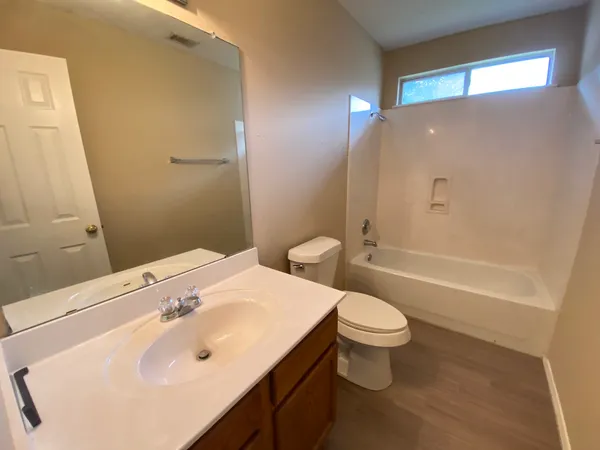 a bathroom with a sink a toilet a mirror and vanity