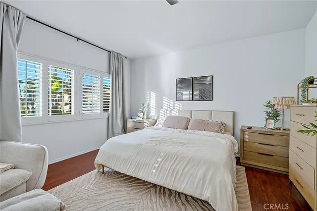 a bedroom with a bed couch and windows