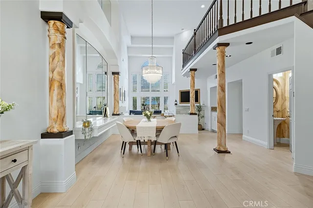 a view of a dining room with furniture a chandelier and wooden floor