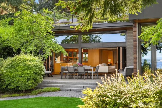 a view of a patio with table and chairs potted plants and large tree