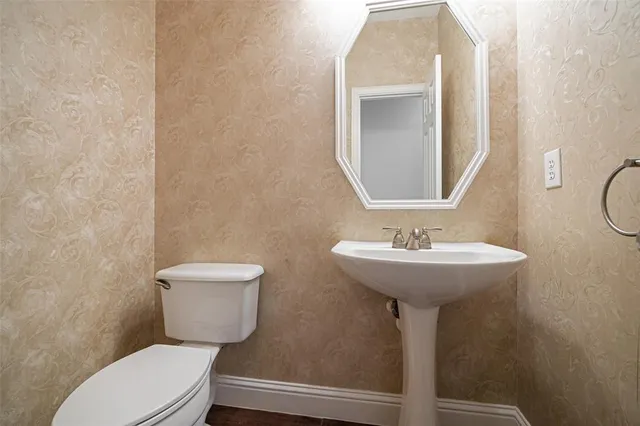 a bathroom with a toilet sink and mirror