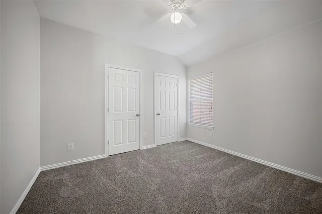 a view of an empty room with a chandelier fan