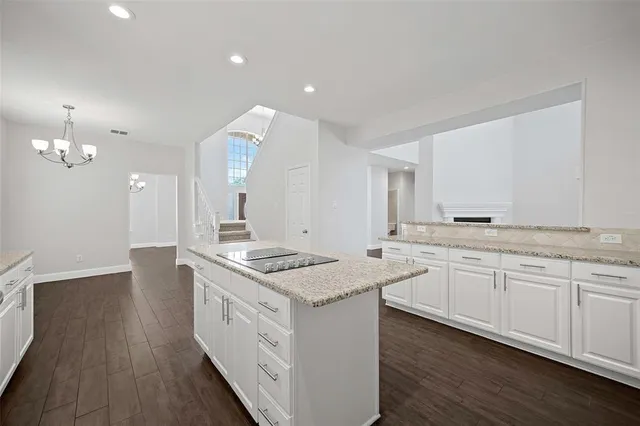 a kitchen with granite countertop a sink stove and wooden floor