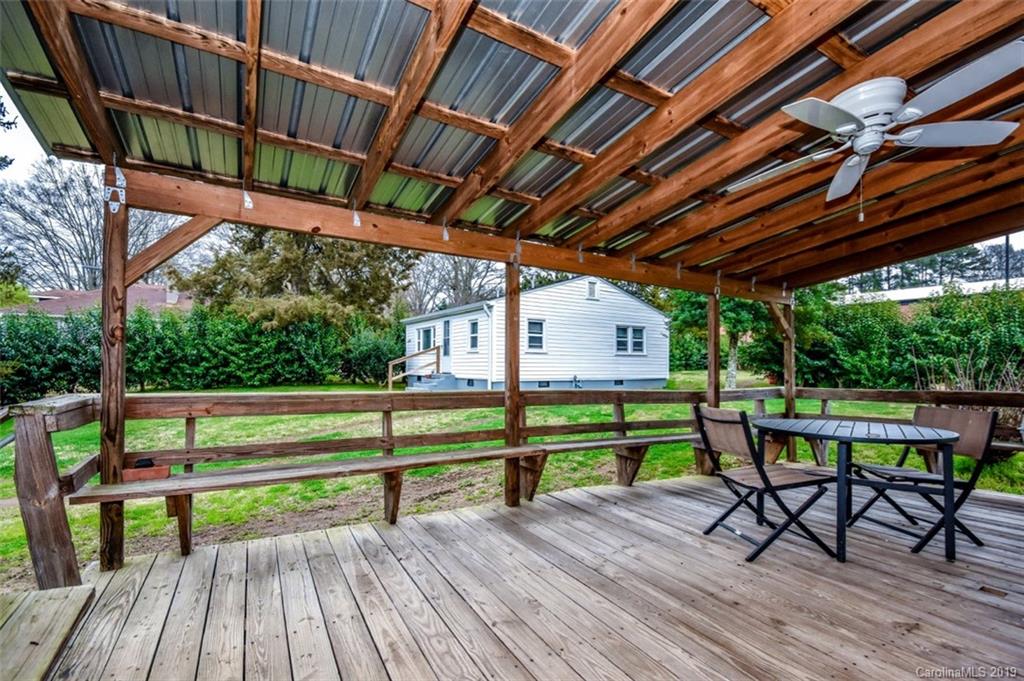 504 Watson Street Davidson, NC 28036 - Photo 15 of 35 a view of porch with a table and chairs under an umbrella with a small yard