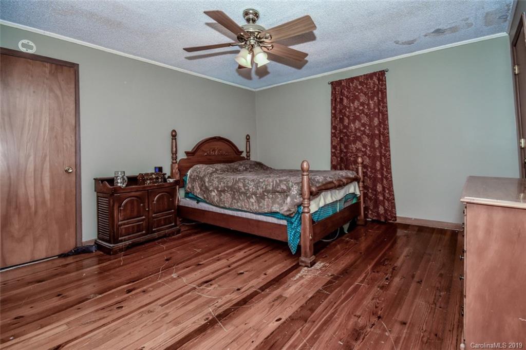 504 Watson Street Davidson, NC 28036 - Photo 22 of 35 a bedroom with a bed and a chandelier