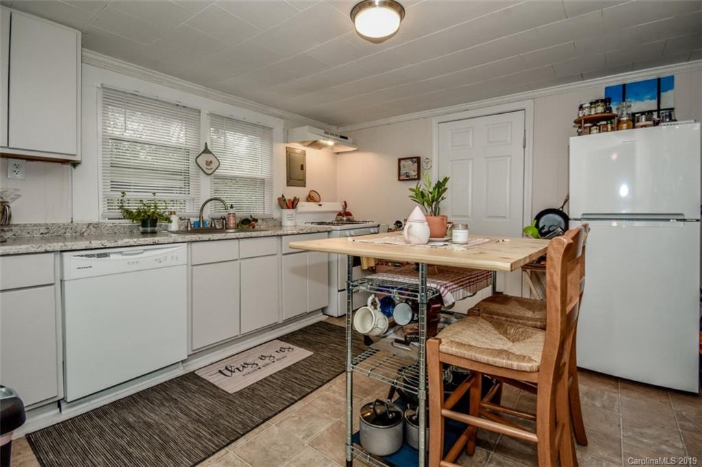 504 Watson Street Davidson, NC 28036 - Photo 25 of 35 a kitchen with a dining table chairs and white cabinets