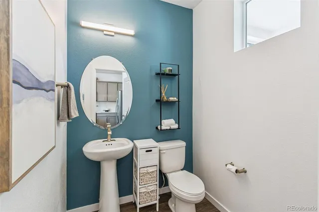 a bathroom with a toilet sink and mirror