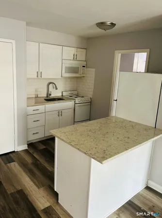 a kitchen with a sink cabinets and wooden floor