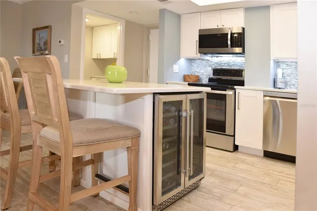 a kitchen with a refrigerator and a stove top oven