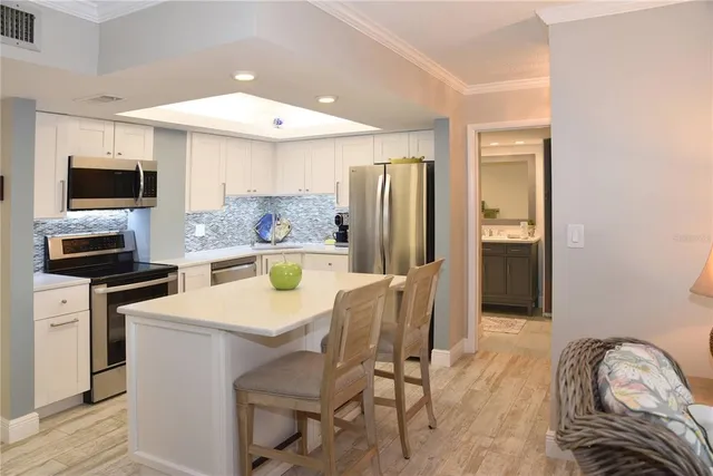a kitchen with stainless steel appliances kitchen island a refrigerator and a stove top oven