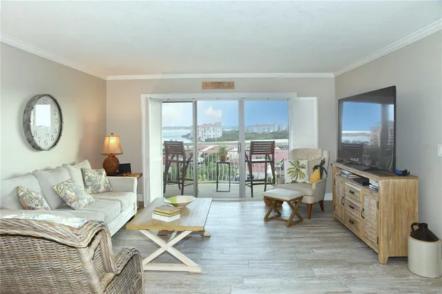 a living room with furniture a flat screen tv and a floor to ceiling window