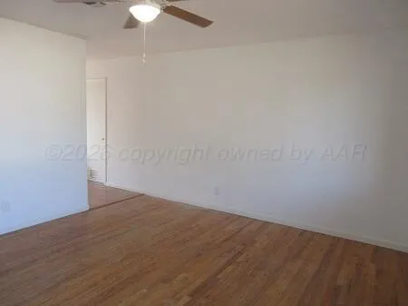 a view of an empty room with a chandelier fan