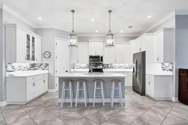 a kitchen with kitchen island granite countertop a sink a center island a stove and cabinets