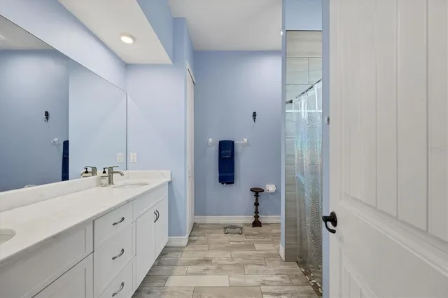 a en suite bathroom with a double vanity sink and a mirror