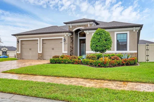 a front view of a house with a garden and plants