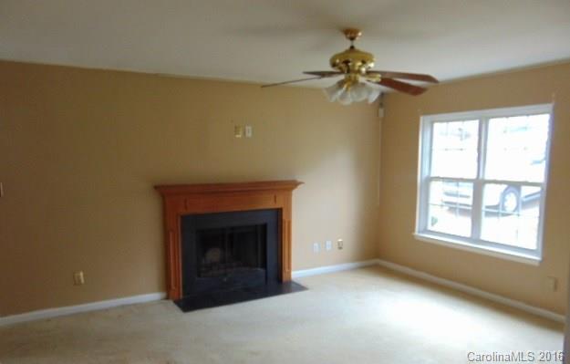 10303 Rockwood Road Charlotte, NC 28215 - Photo 3 of 12 an empty room with a fireplace and a window