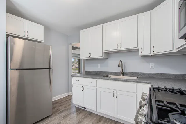 a kitchen with refrigerator a stove a sink and cabinets