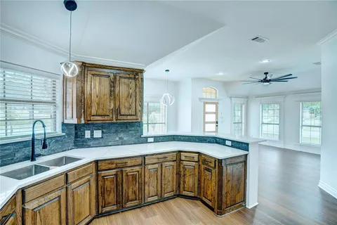 a kitchen with stainless steel appliances granite countertop a sink a stove cabinets and wooden floor