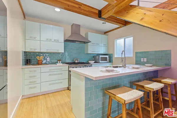 a kitchen with kitchen island granite countertop a sink and chairs