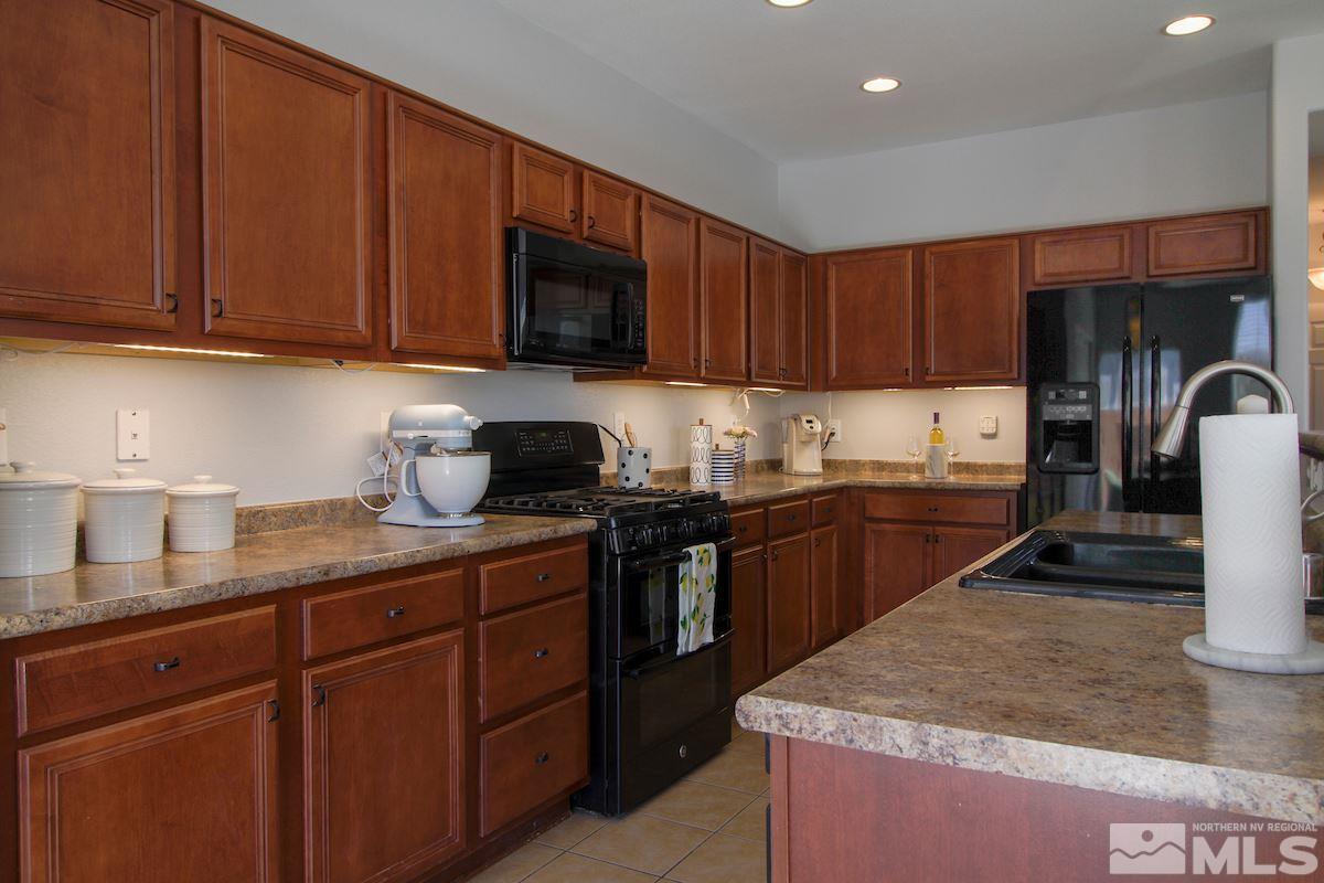 8903 Wynne Street Reno, NV 89506 - Photo 8 of 17 a kitchen with stainless steel appliances granite countertop a sink stove and refrigerator