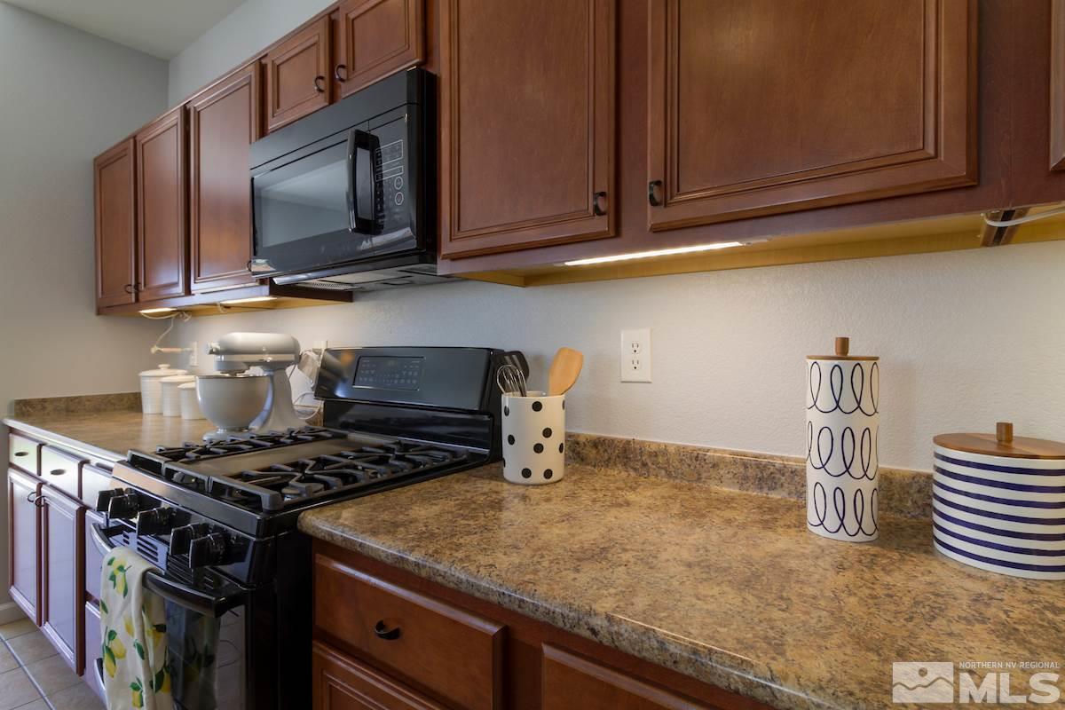 8903 Wynne Street Reno, NV 89506 - Photo 9 of 17 a kitchen with wooden cabinets and a stove top oven