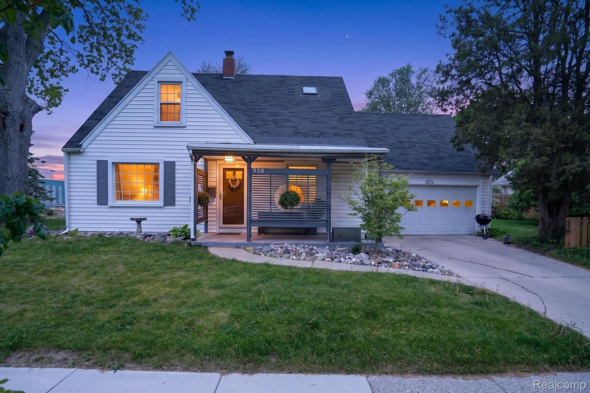 338 Kensington Road Lansing, MI 48910 - Photo 1 of 35 View of front of home featuring a lawn, an attached garage, covered porch, a chimney, and concrete driveway