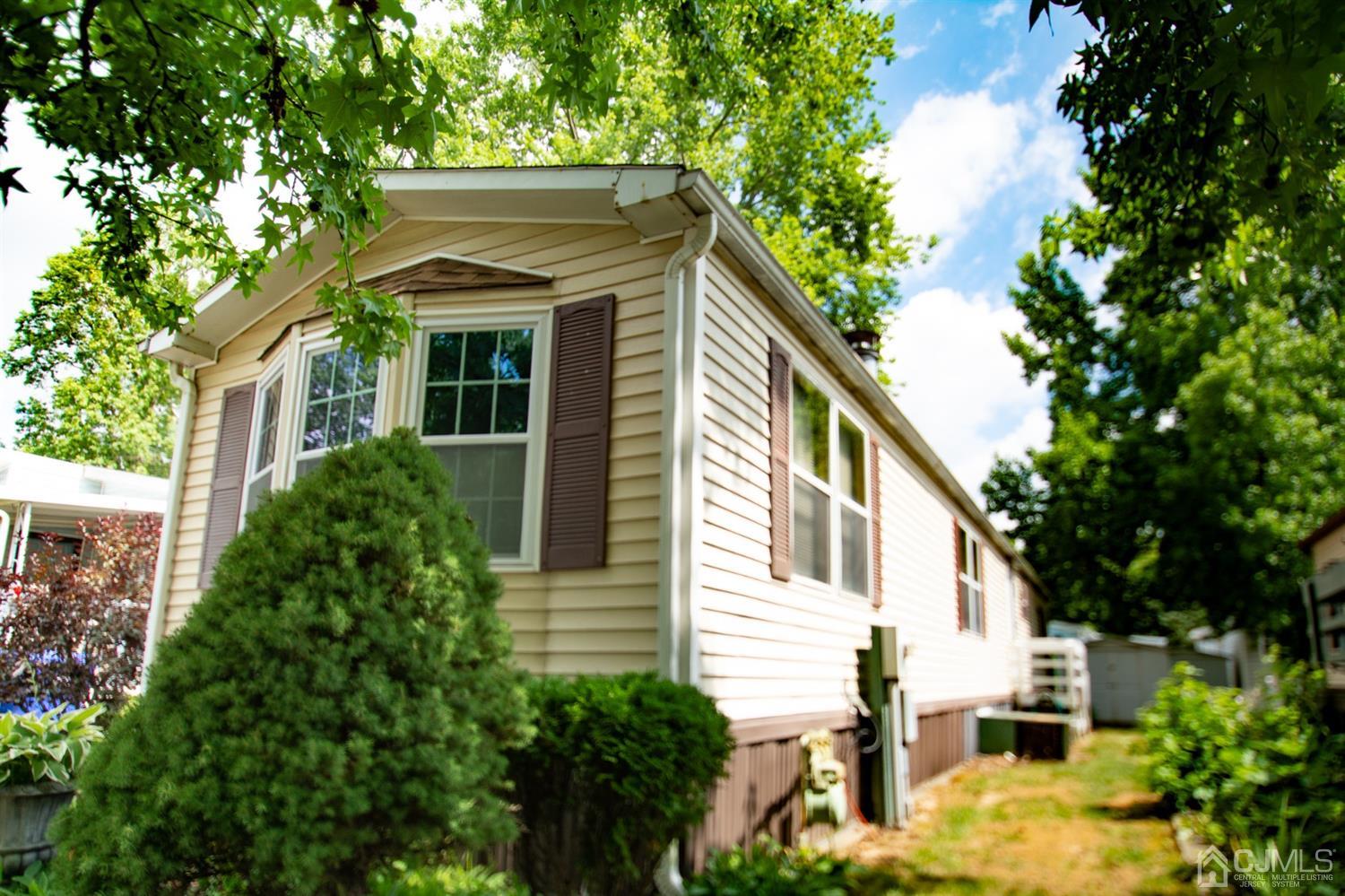 47 Poe Road North Brunswick, NJ 08902 - Photo 5 of 19 a view of a white house with large windows and a small yard