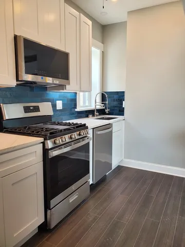 a kitchen with granite countertop a stove and a microwave