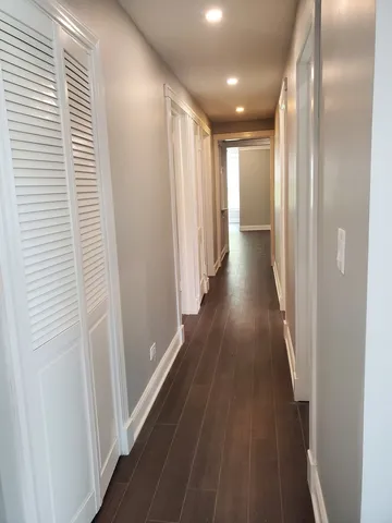 a view of a hallway with wooden floor