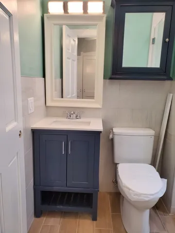 a bathroom with a toilet sink and mirror