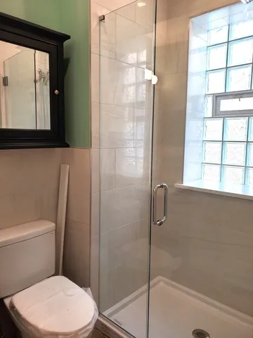 a bathroom with a toilet and a shower