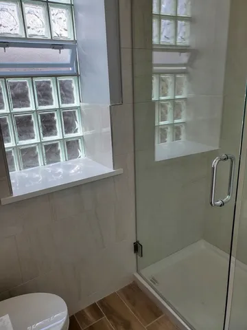 a bathroom with a toilet and a shower
