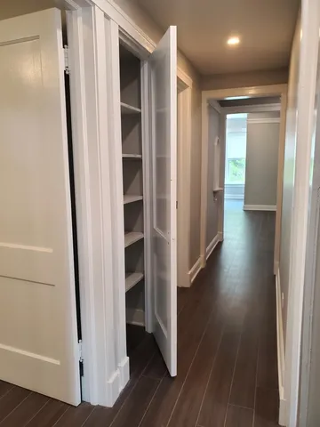 a view of a hallway with wooden floor and entryway