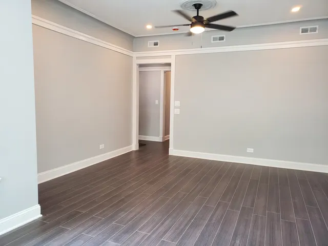 a view of an empty room with wooden floor