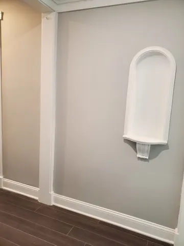 a view of a small space with wooden floor and a window