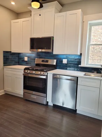 a kitchen with granite countertop a stove and a microwave