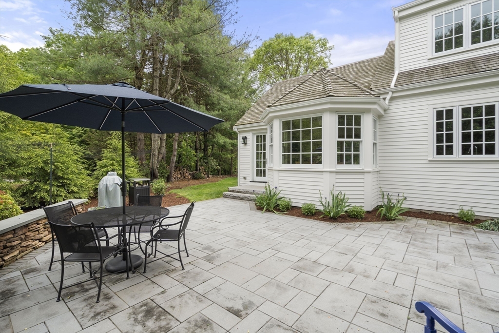 12 Pheasant Landing Road Needham, MA 02492 - Photo 38 of 42 a view of a house with backyard sitting area and blue umbrellas
