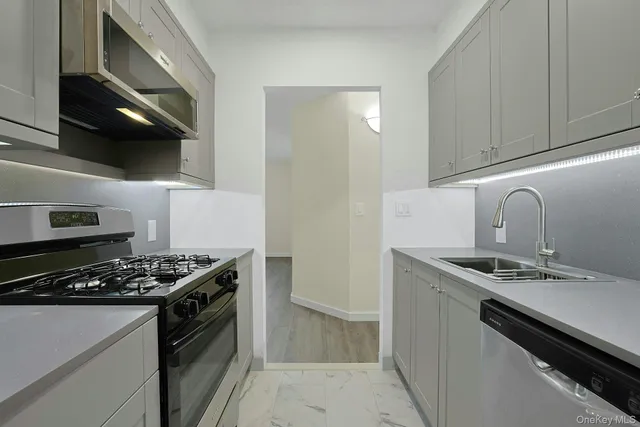 a kitchen with stainless steel appliances granite countertop a sink and a stove