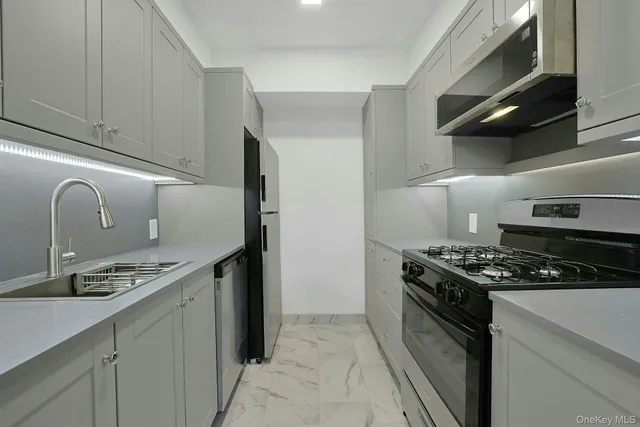 a kitchen with stainless steel appliances granite countertop a stove and a sink