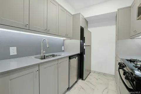a kitchen with stainless steel appliances granite countertop a sink and a refrigerator