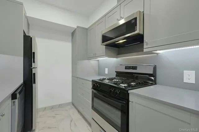 a kitchen with stainless steel appliances granite countertop a stove and a microwave