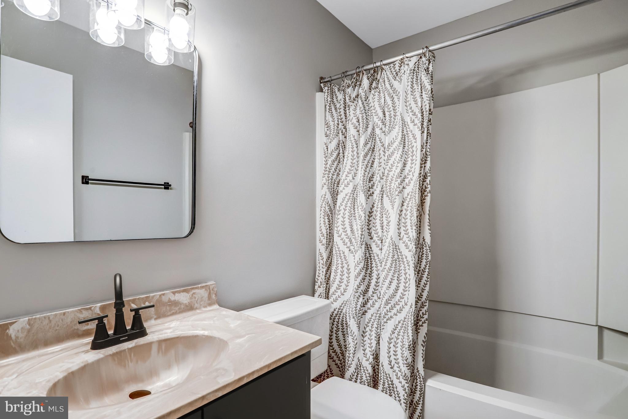 1953 Lakeport Way Reston, VA 20191 - Photo 31 of 60 a bathroom with a sink a toilet and shower curtain