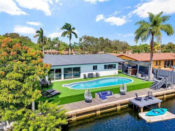 a front view of a house with swimming pool having outdoor seating